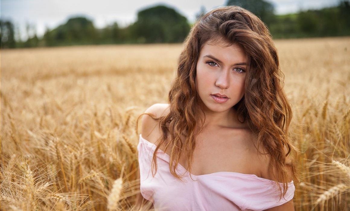 Portrait de Marine en robe rose dans un champ de blé